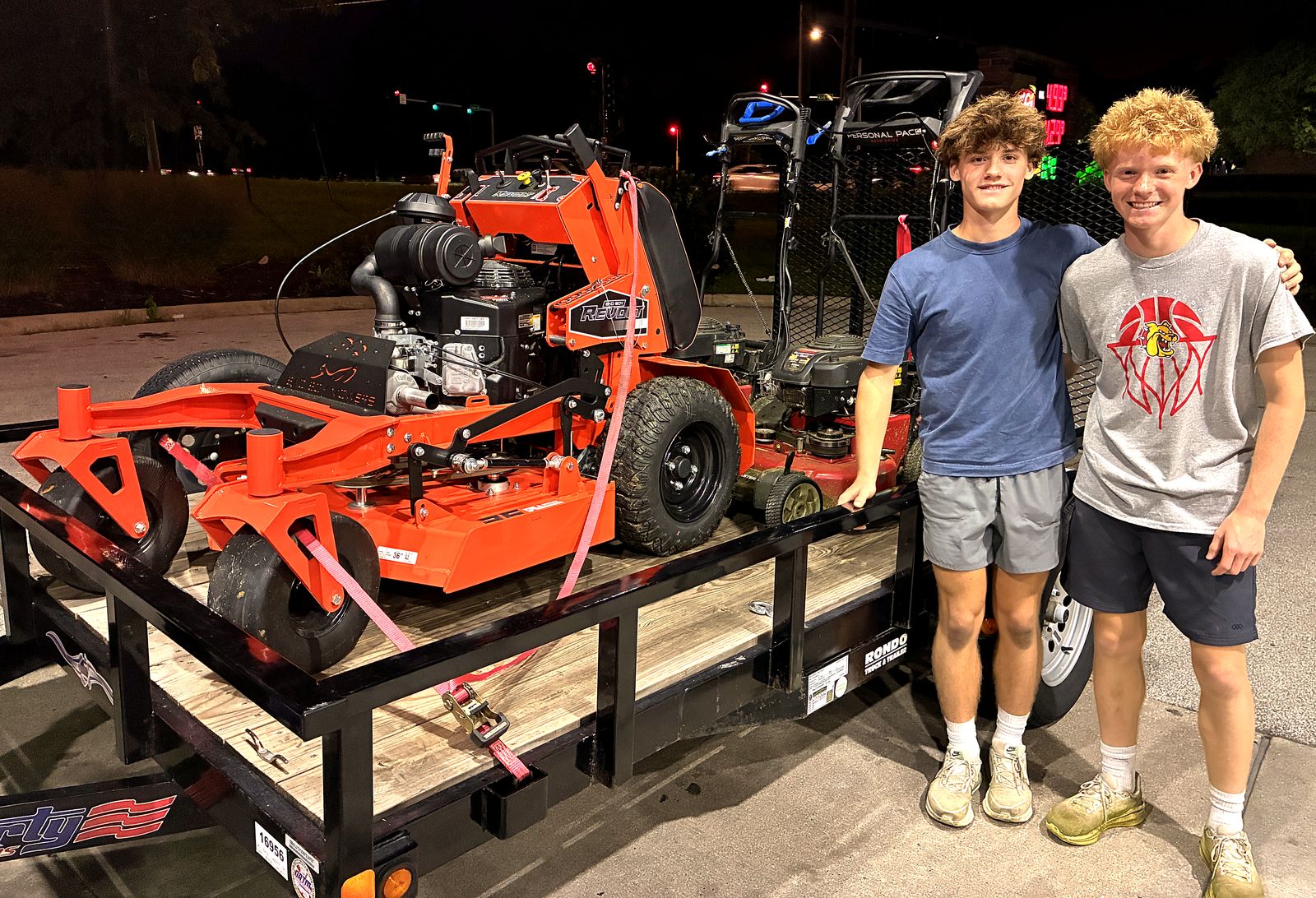 Jeremy and his younger brother Nate with their mower and trailer, owners of Bulldog Mowing