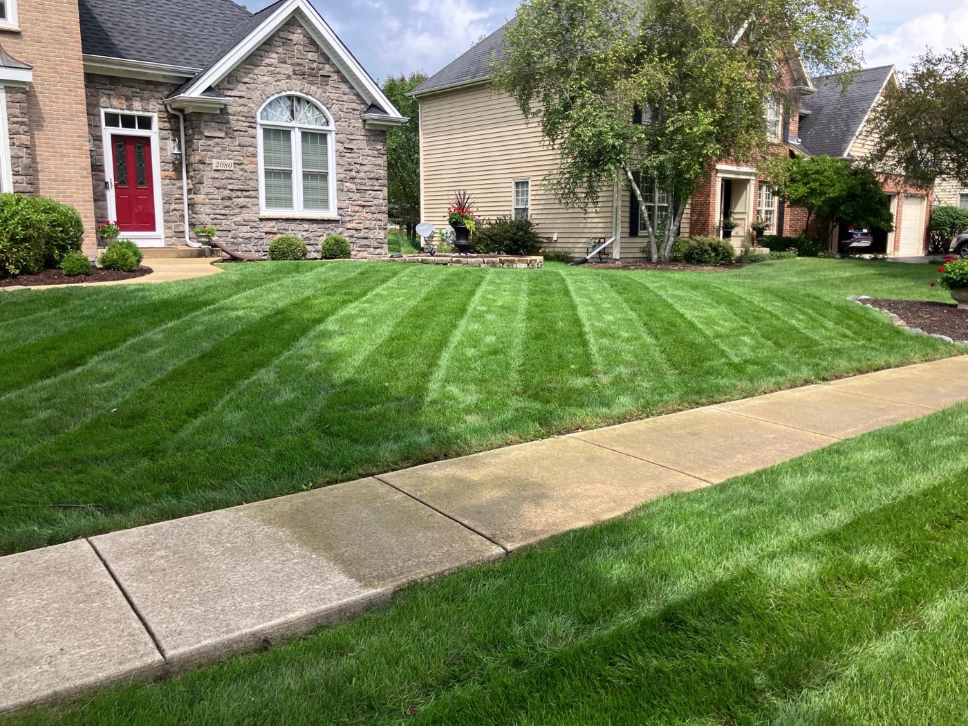 Freshly striped front lawn in front of a stone house in Batavia, IL